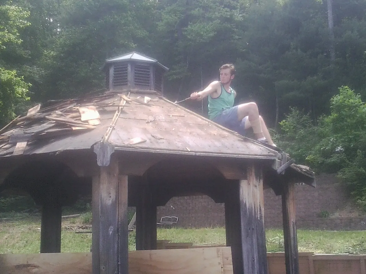 Tearing the old roof off a wooden gazebo before new shakes in Sandy Hook